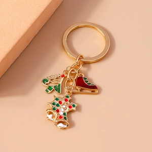 Detail of Christmas keychain with gold bell, red skate shoe and festive enamel charms