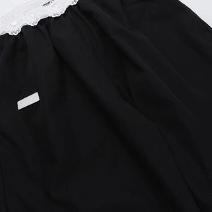 Détail de tissu noir avec bordure en dentelle blanche et étiquette de marque denim