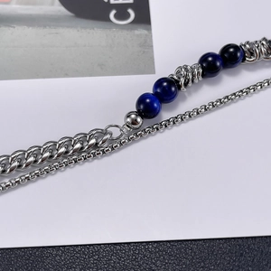 Detail of double-layer stainless steel bracelet with blue tiger eye stone and Cuban chain