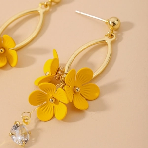 Macro detail of golden flower earrings with matte yellow petals and zircon drops
