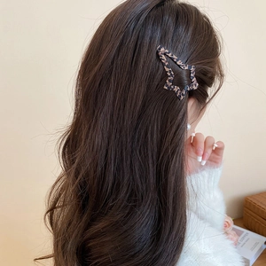 Vista dettagliata di un fermaglio per capelli a stella leopardato su capelli mossi