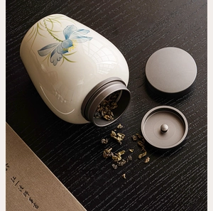 Detailed close-up of a blue lotus ceramic tea canister with dual airtight metal lids