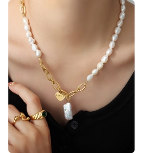 Detailed shot of 18K gold plated heart pendant with 'LOVE' engraving and baroque pearl