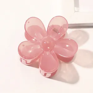 Detail shot of a pink floral hair claw clip made of translucent acrylic with a metal spring