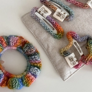 Detail of rainbow handmade crochet hair clip and scrunchie set with cute rabbit labels