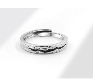 Detail of silver adjustable ring with hammer texture and central black epoxy line
