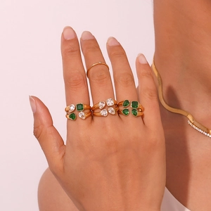 Close-up of gold double-layer rings with heart and teardrop zircon stones on finger