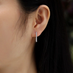 Close-up of elegant silver double-row moissanite hoop earrings worn by a model