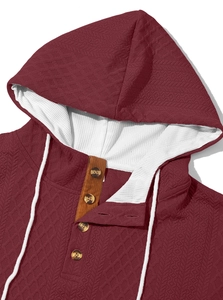 Détail du sweat bordeaux montrant le motif jacquard et la capuche gaufrée