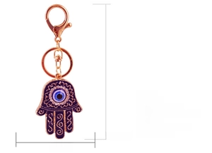 Detail view of the rose gold Hamsa Hand keychain with blue evil eye and sparkling rhinestones