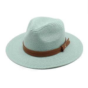 Détail du chapeau de paille vert menthe avec ruban en cuir marron et rivets dorés