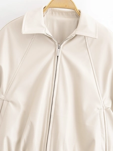 Detail of cream faux leather jacket showing lapel collar and metal zipper closure