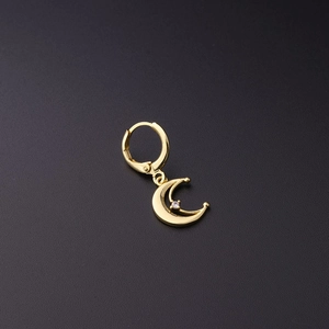 Detailed macro view of a gold crescent moon earring with a sparkling zircon inlay