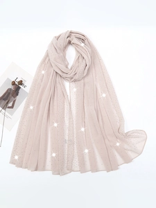Macro shot of elegant beige chiffon shawl with shimmering rhinestones for evening wear