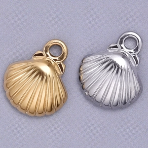 Macro view of shell-shaped metal pendants in gold and silver finish with ring loops