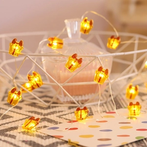 Close-up of warm yellow Christmas gift box LED string lights in a cozy home setting