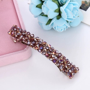 Detail of four-row crystal spring hair clip with dark brown and purple beads on pink velvet box