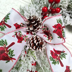 Christmas wreath with cardinal ribbon, pine cones, and frosted pine needles decoration