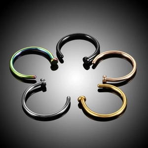 Five colored stainless steel piercing rings arranged in a flower shape on black surface