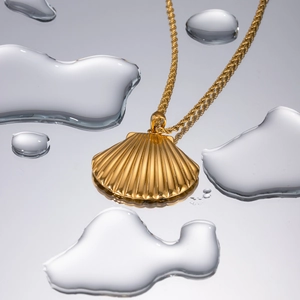 Collier avec pendentif coquillage en acier plaqué or 18k et gouttes d'eau sur miroir