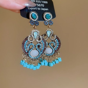 Detail of vintage bohemian drop earrings with turquoise stones and 925 silver fringe
