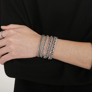 Detailed close-up of a silver stainless steel Cuban link bracelet wrapped on a wrist