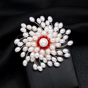 Handmade luxury pearl snowflake brooch with red beads on a black jewelry box