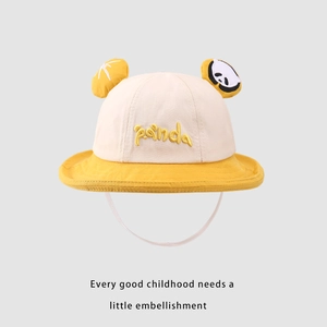 Dettaglio di un cappello da pescatore giallo per bambini con ricamo panda e cordino