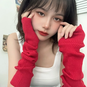 Close-up of red ribbed knit fingerless arm warmers with a stylish slouchy texture