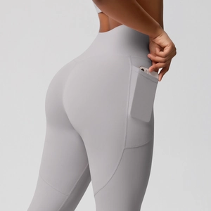 Close-up of high waist light grey yoga pants featuring a practical side phone pocket detail
