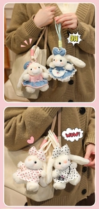 Detailed plush bunny keychains in various outfits hanging on a canvas tote bag