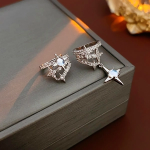 Detailed view of asymmetric star-shaped silver ear cuffs with zircons on a jewelry box