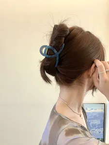 Gros plan d'une pince à cheveux torsadée bleu marine sur les cheveux du mannequin