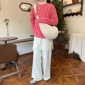 Detail shot of the large white pleated crossbody dumpling bag in a cozy winter setting