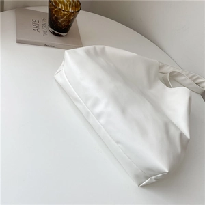 Minimalist white soft PU leather tote bag shown in a stylish lifestyle setting