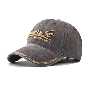 Detail of dark grey washed cotton baseball cap with yellow Bourbon St embroidery