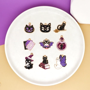 Set of 9 Halloween enamel charms including black cat and wizard hat on a white plate