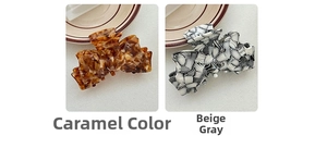 Détail de pinces à cheveux en acétate ambre caramel et gris beige sur une assiette