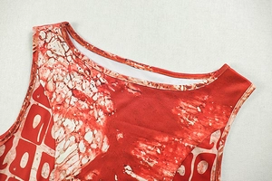 Detail of crew neck sleeveless dress featuring red-orange abstract art print pattern