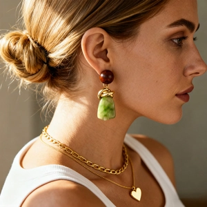Vintage resin geometric earrings and gold layered heart necklace on model