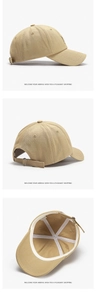 Detail view of khaki cotton baseball cap showing 100% cotton label and metal buckle strap