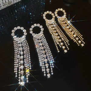 Macro shot of sparkling silver and gold tassel earrings with brilliant zircon crystals