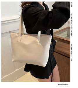 Fashionable minimalist cream white tote bag shown on model in modern indoor setting