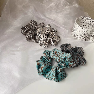 Silk scrunchies set featuring elegant houndstooth and leopard print patterns on satin fabric