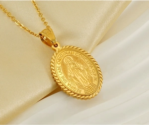 Macro shot of gold plated stainless steel Virgin Mary oval pendant on beige silk