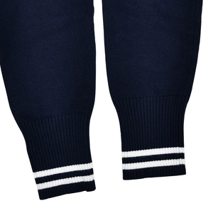 Macro shot of navy blue knit sweater cuffs featuring double white stripe detail and texture