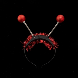 Detail view of red sequin spring balls and glitter wire on a black festive headband