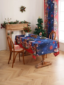 Detail of Christmas tablecloth with Santa and bear patterns on a blue fabric base