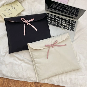 Dettaglio custodia PC imbottita con fiocchi rosa nei colori nero e crema