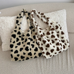 Detailed view of plush heart tote bags in beige and white with soft faux fur texture